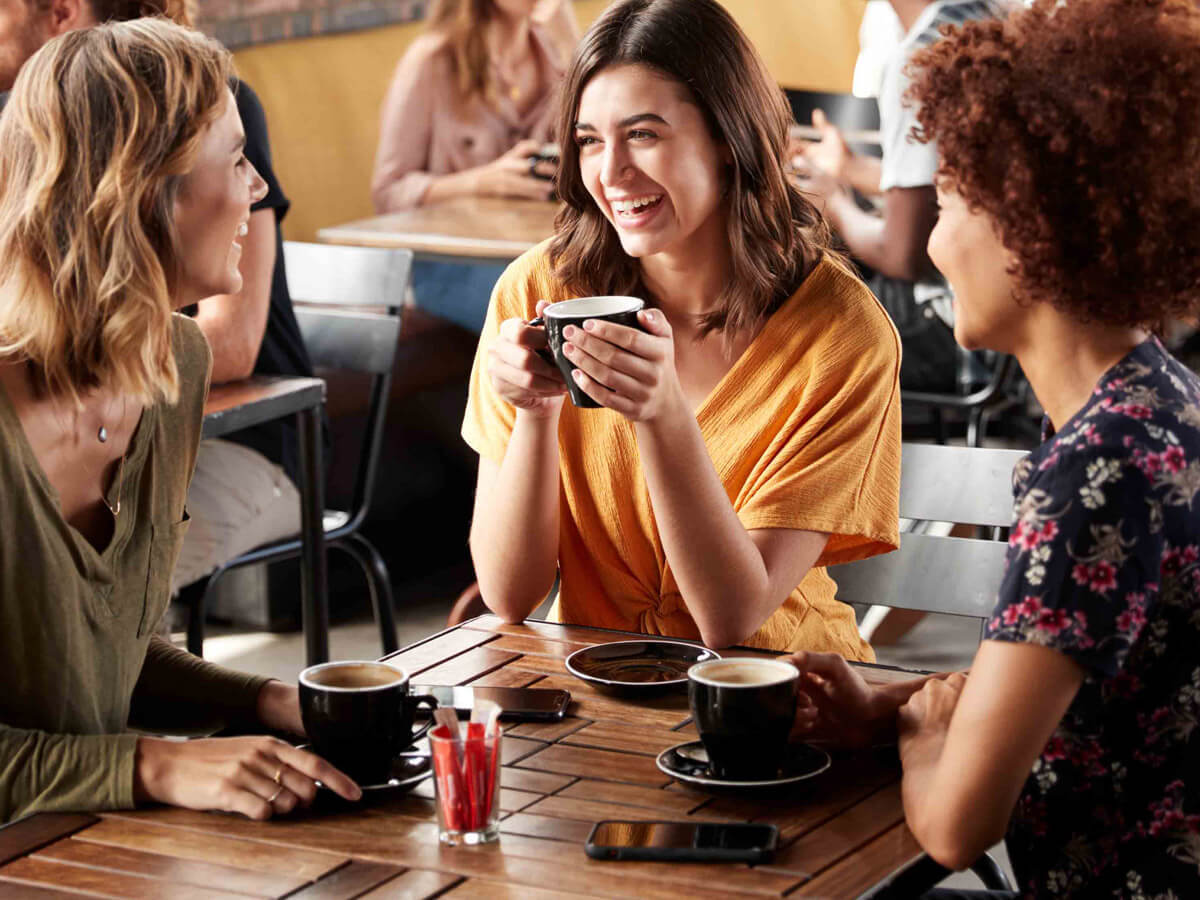 Friends seated enjoying coffee at a cafe