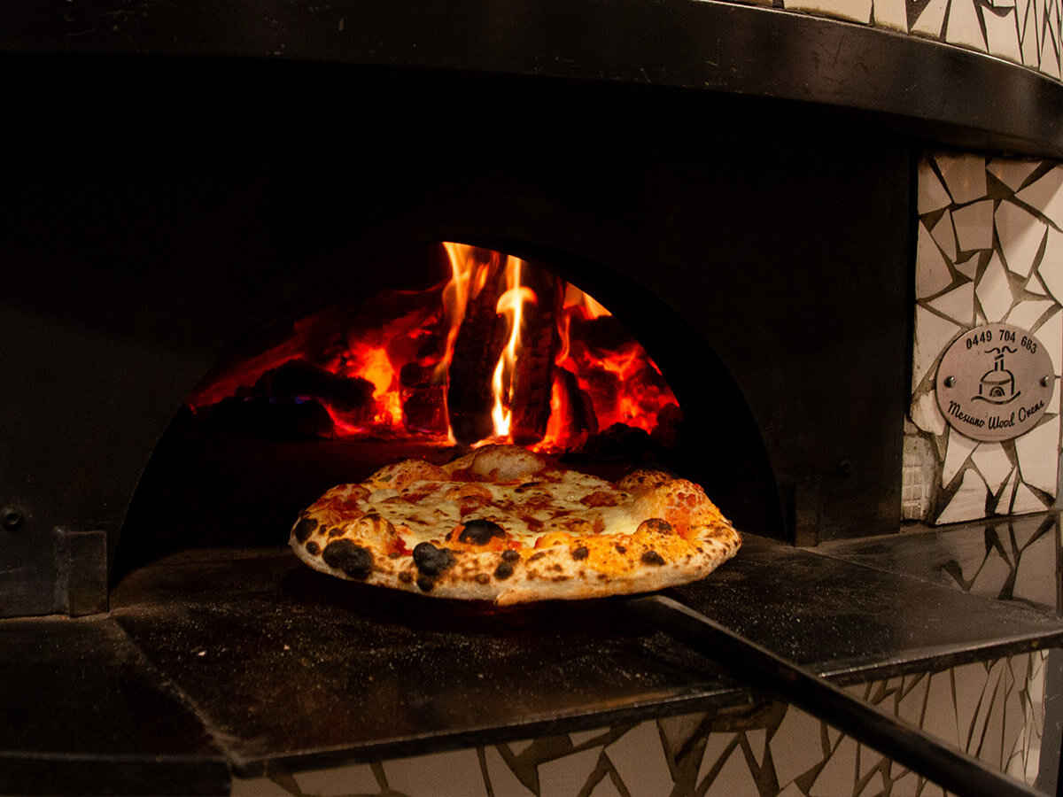 Pizza being put into a pizza oven