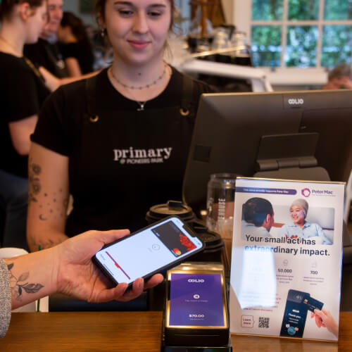 Customer paying on EFTPOS terminal at cafe