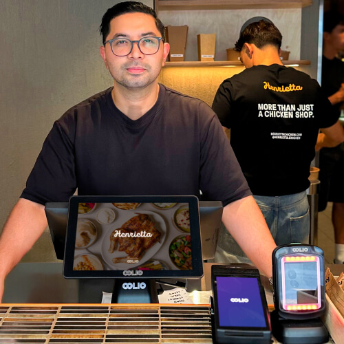 Henrietta's manager behind the counter with Oolio POS and Customer Display