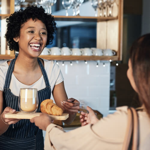 Staff member serving people at the cafe